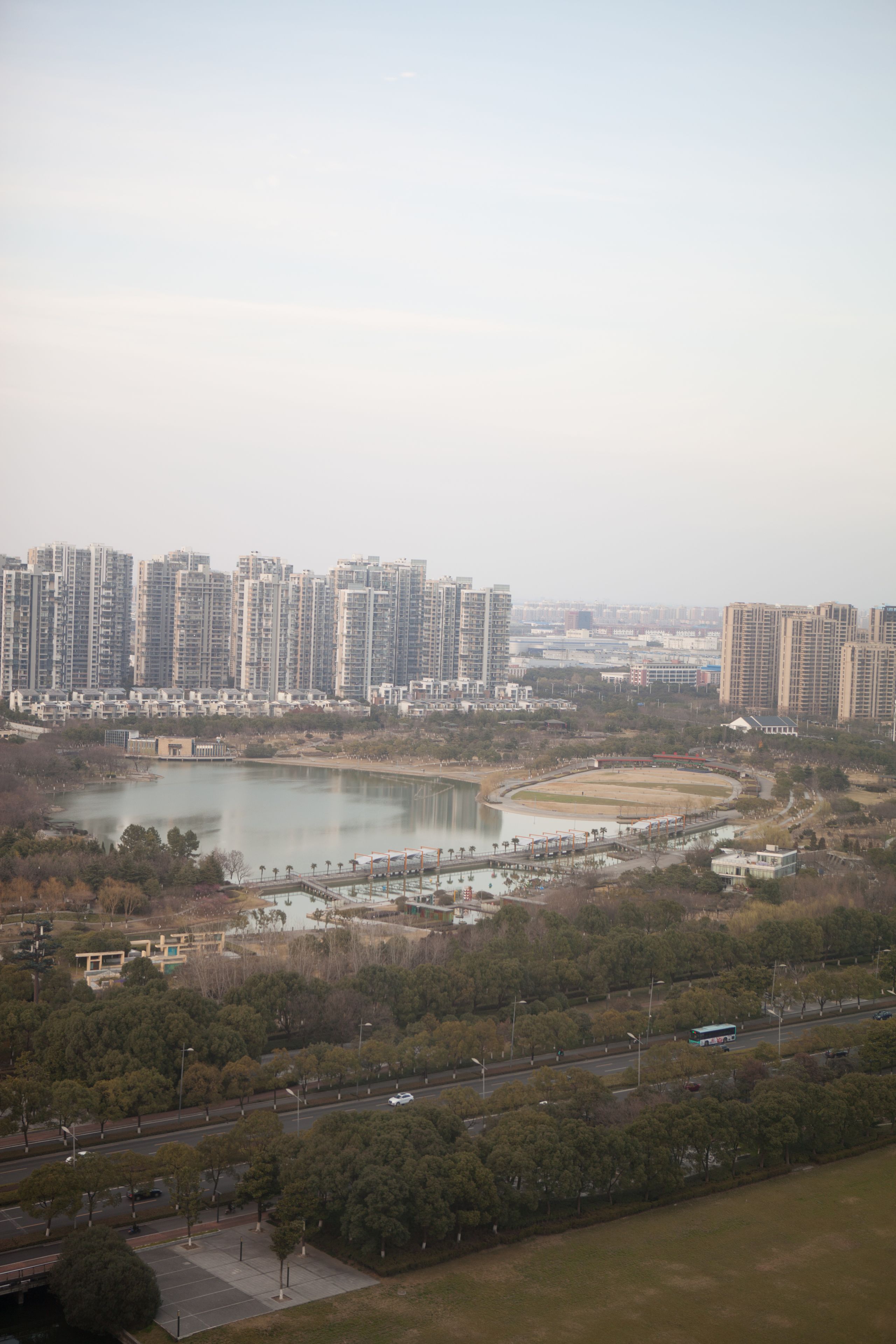 A high-rise residential area with a lake, roads, and greenery.