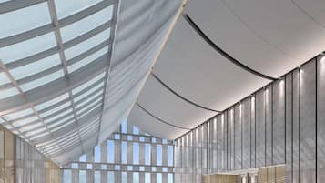 A modern indoor swimming pool with a high ceiling and large windows.