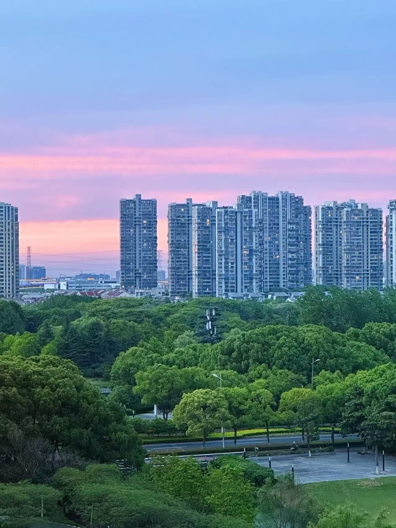 A cityscape with high-rise buildings and a park area.