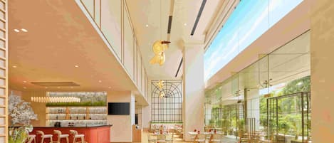 A spacious indoor dining area with high ceilings, large windows, and a central bar area.