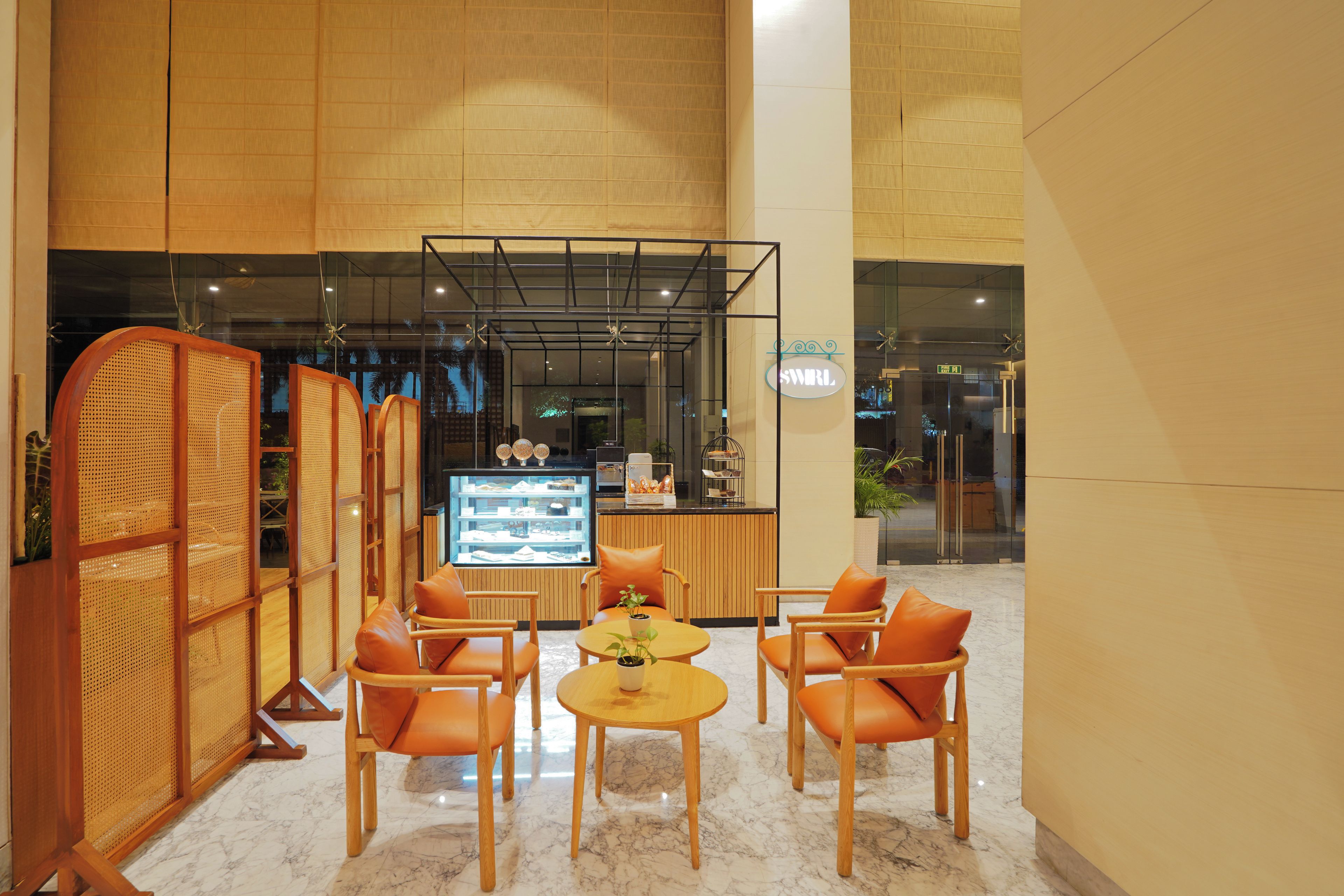 Un interior moderno con una zona de estar, una vitrina de vidrio y un separador de madera.