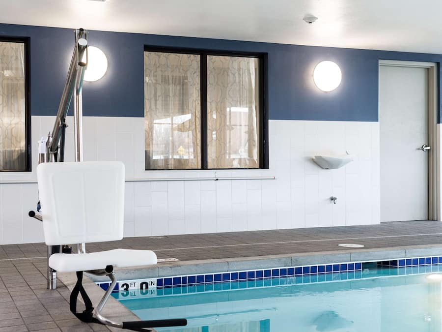 A swimming pool with a chair, a window, and a door.