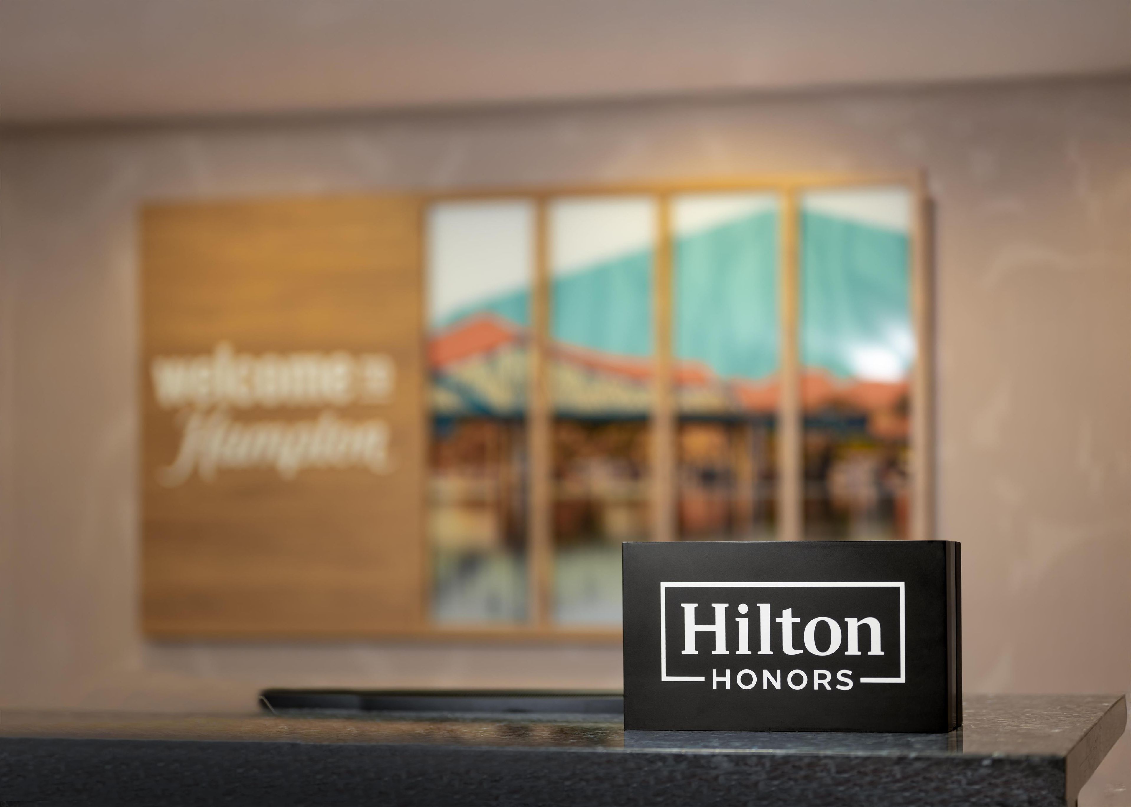 Un letrero negro con la leyenda "Hilton Honors" sobre un mostrador de recepción.