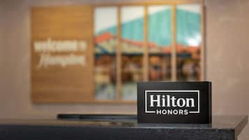 Un letrero negro con la leyenda "Hilton Honors" sobre un mostrador de recepción.
