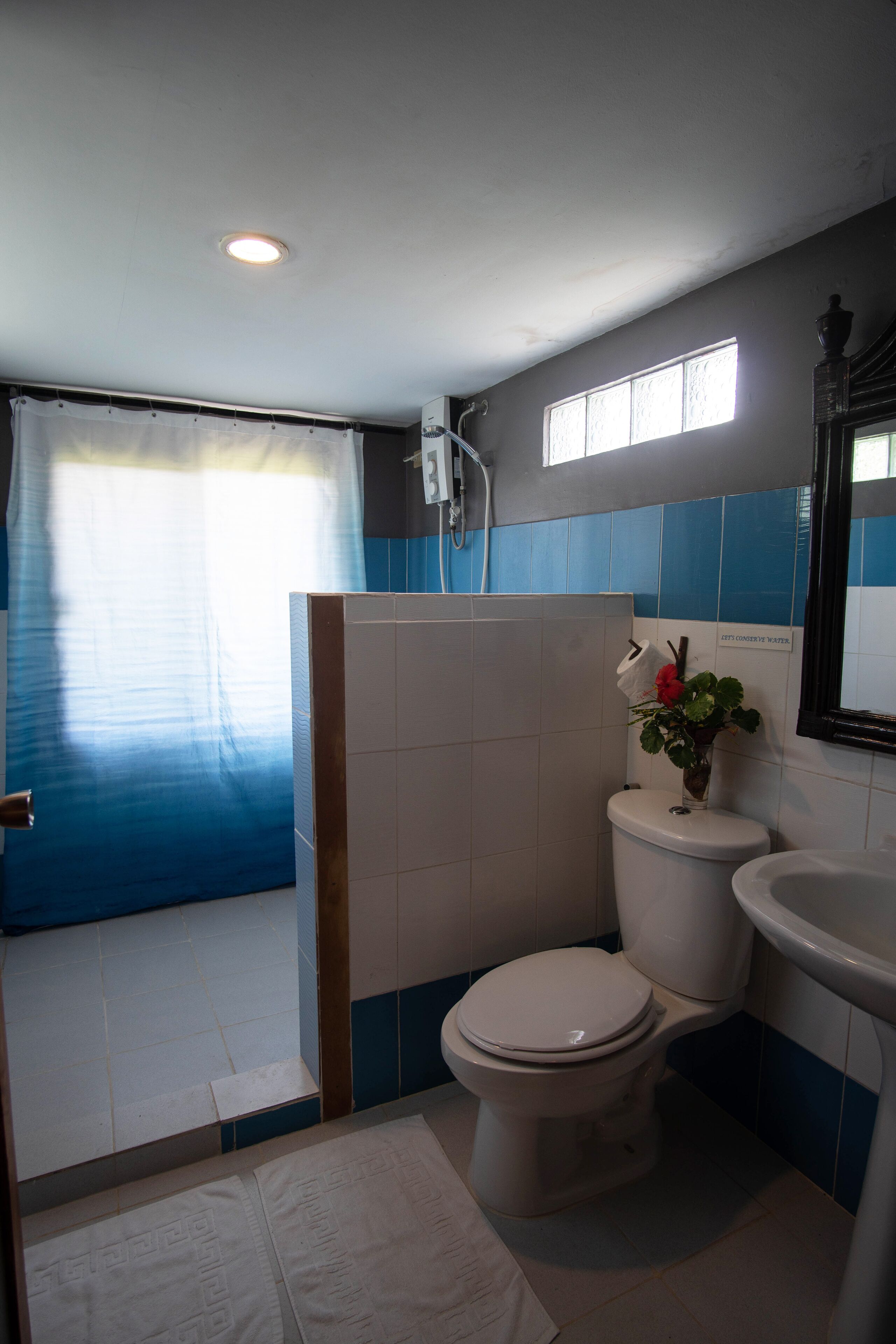 A bathroom with a toilet, sink, and shower area.