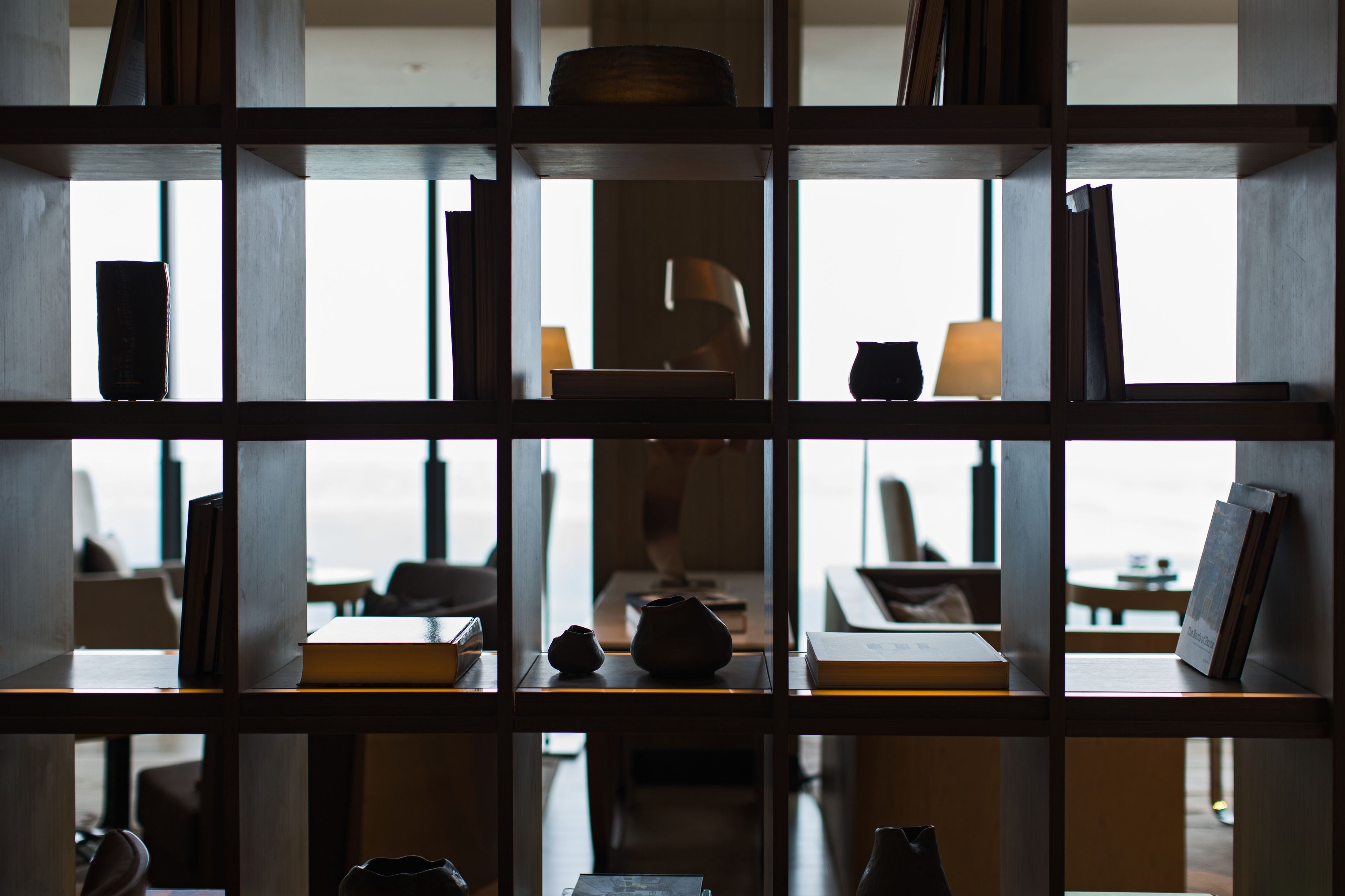 Ein Zimmer mit einem Holzbücherregal, gefüllt mit Büchern und Dekoration.