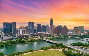 A city skyline with modern buildings, a river, and a bridge. - Holiday Inn Express & Suites Austin - Round Rock Area by IHG (Austin)