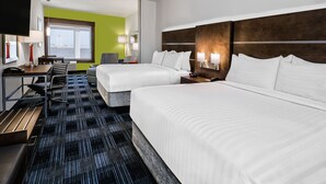 Une chambre d’hôtel avec deux lits, un bureau avec une chaise, une télévision et une grande fenêtre donnant sur un beau paysage.