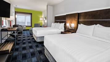 A hotel room with two beds, a desk, a chair, a TV, and a window with a view.