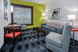 A room with a dining table, chairs, a sofa, and a patterned carpet. - Holiday Inn Express & Suites Austin - Round Rock Area by IHG (Austin)