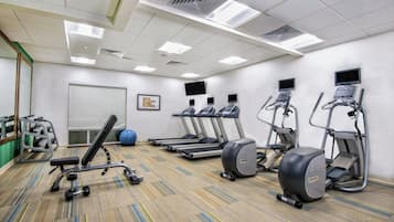 A gym with treadmills, elliptical machines, and free weights.