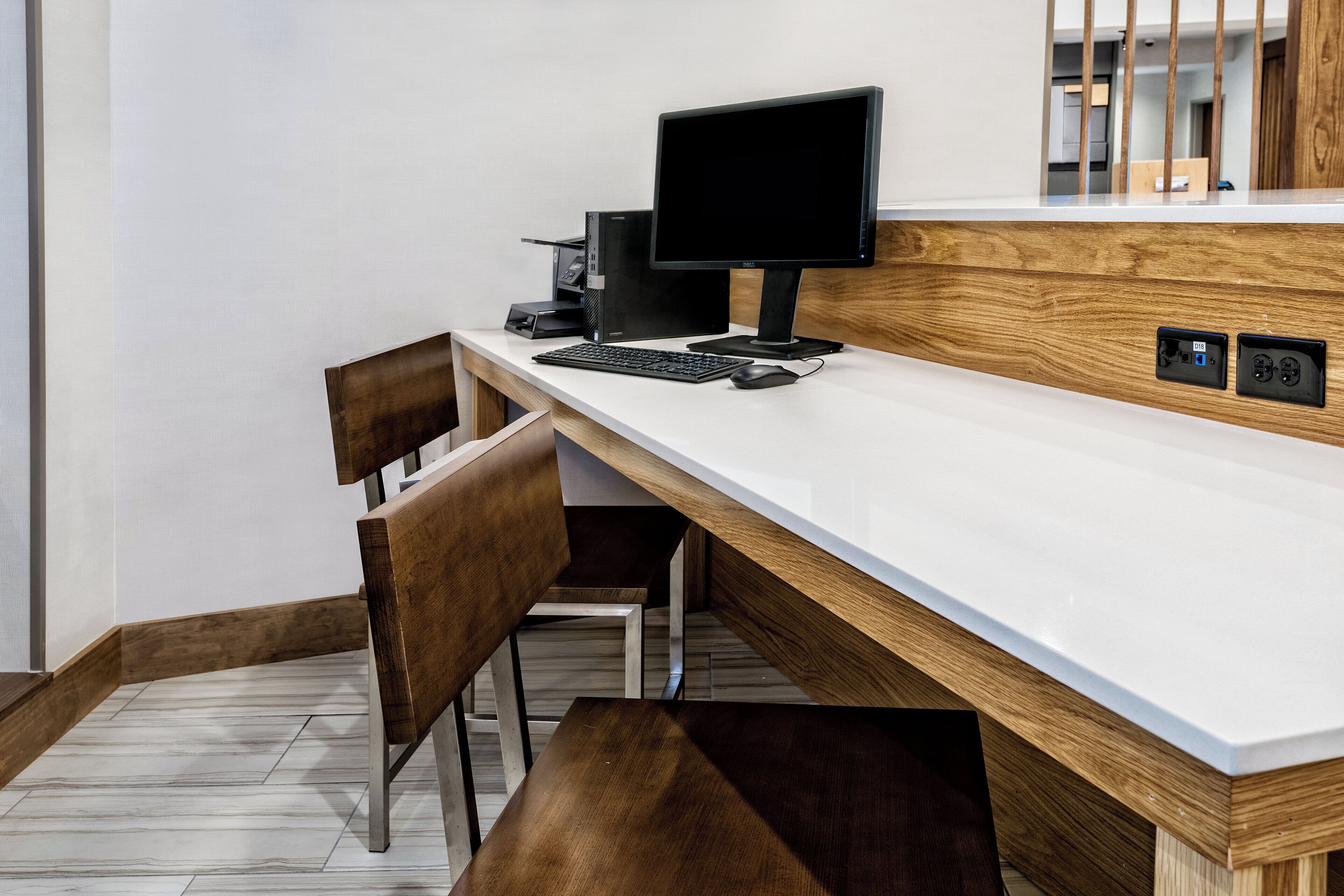 A modern office desk with a computer, keyboard, and mouse.
