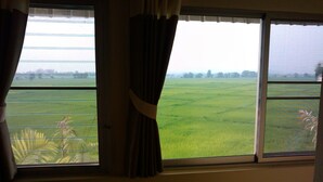 Una habitación con un amplio ventanal con vistas a un campo verde.