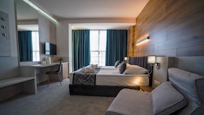 Una habitación de hotel moderna con cama, escritorio, silla y sofá.