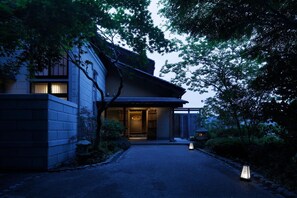 A traditional Japanese house with a wooden exterior, a tiled roof, and a well-maintained garden. - Yuzuya Ryokan Kanazawa Ryokusone (Kanazawa)