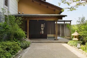 A traditional Japanese building with a wooden entrance and a black shoji screen.
