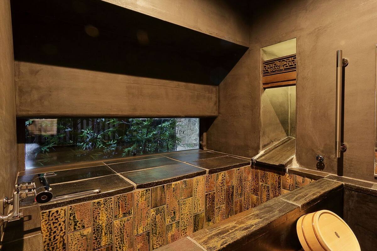 A modern bathroom with a large window, a sink, and a toilet.