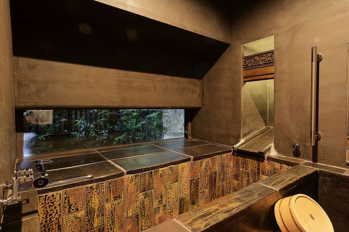 Un baño moderno con un ventanal grande, un lavabo y un inodoro.