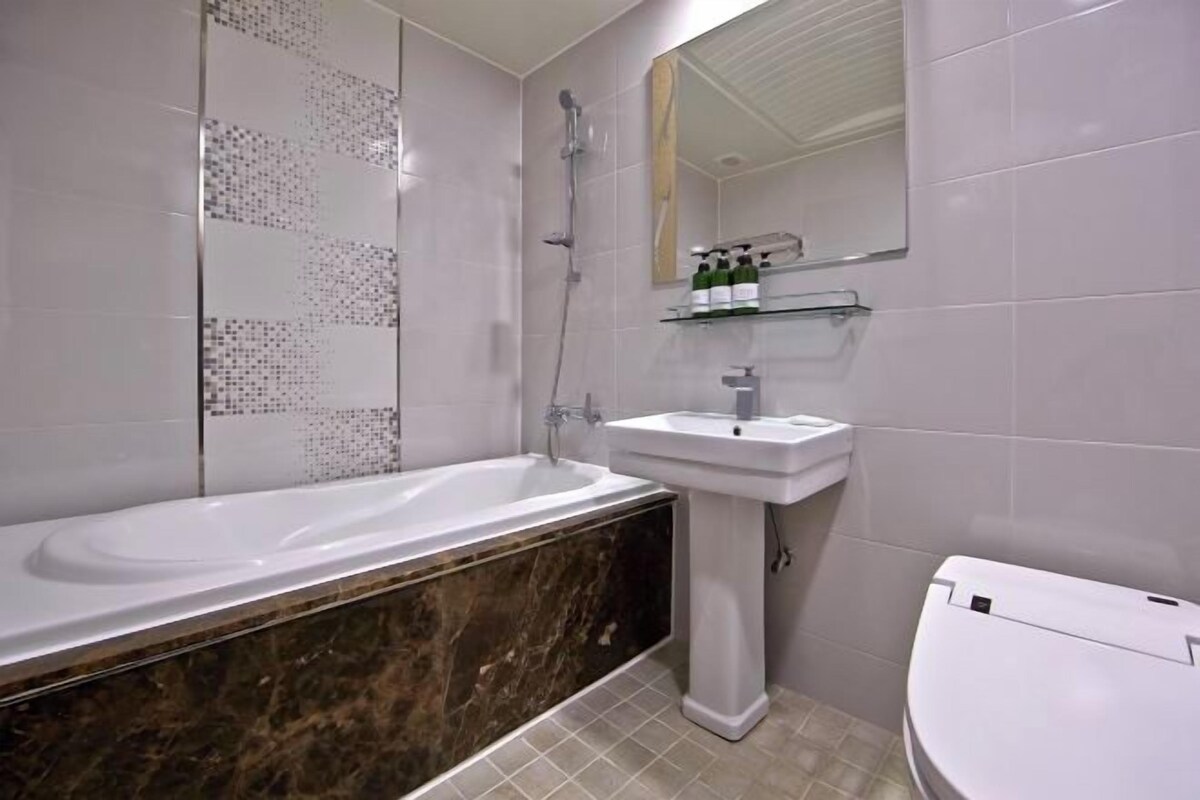 A modern bathroom with a bathtub, a sink, and a toilet.