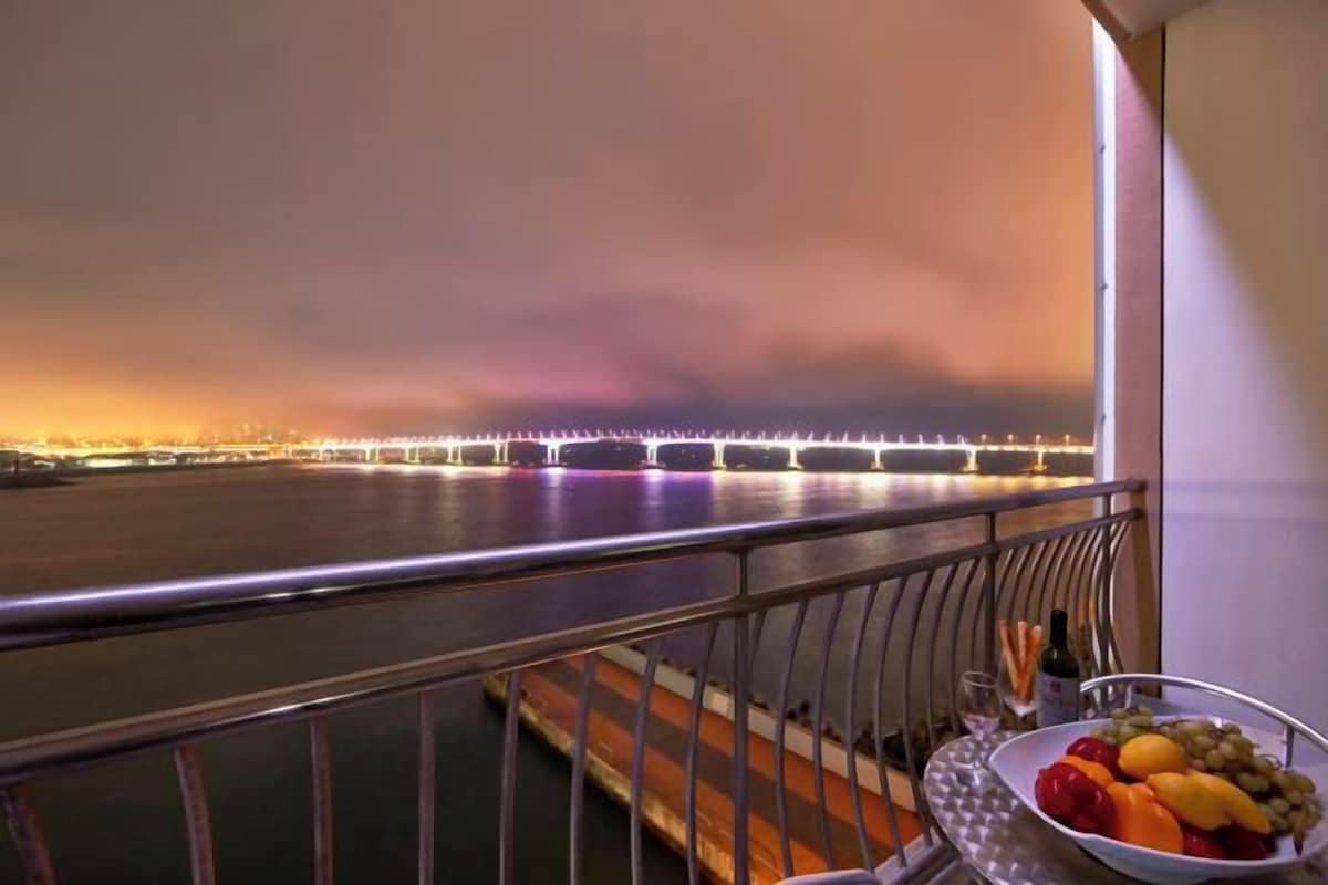 A balcony with a view of a bridge at night.
