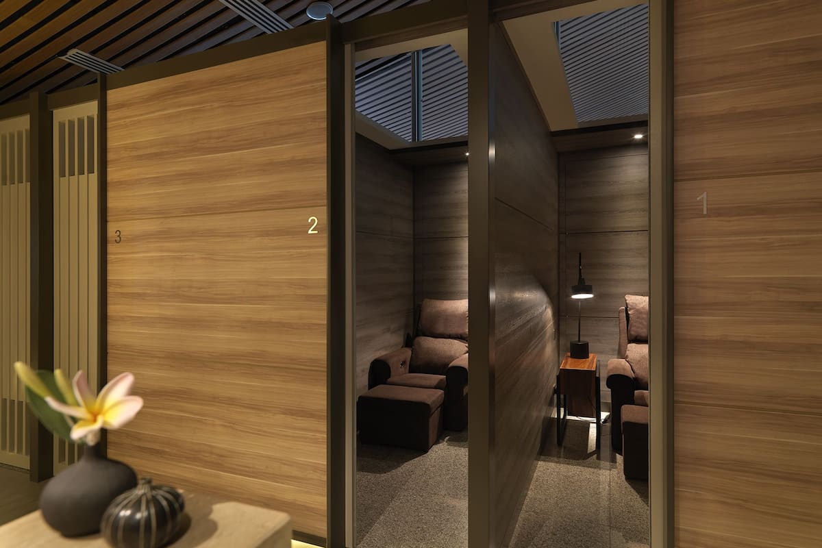 Una habitación moderna con suelo de madera, un sofá, una mesita y una lámpara.