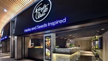 A modern interior with a reception desk, a neon sign reading "Flight Club," and a menu display.