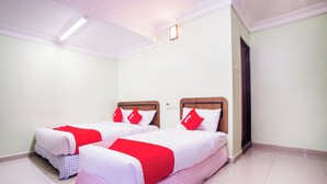 A hotel room with two beds, each with a wooden headboard, white bedding, and red pillows. - Hotel O Casavilla Hotel (Batu Caves)