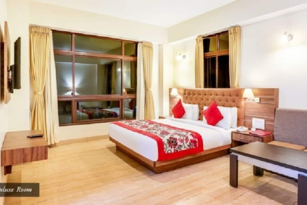 Ein komfortables Zimmer mit einem großen Bett, einer Sitzecke, einem Nachttisch und einem fensterbepflanzten Fenster.
