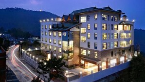 Ein mehrstöckiges Hotel mit modernem architektonischen Design, das einen markanten Hauseingang und mehrere Balkone aufweist.