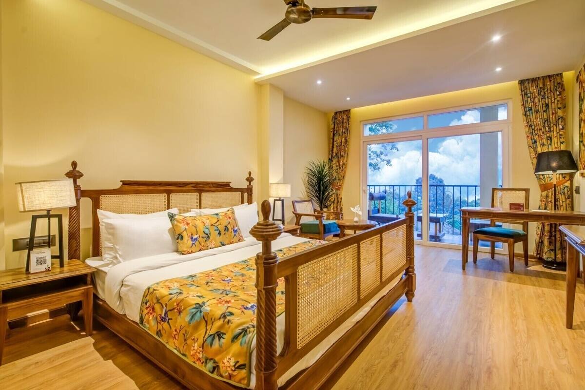 Un dormitorio amplio con una cama grande, un balcón con vistas y un comedor.