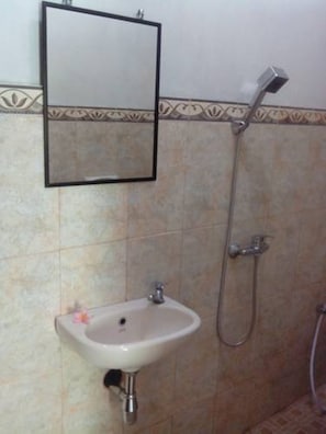A bathroom with a sink, mirror, and shower. - Karma House Ubud (Ubud)