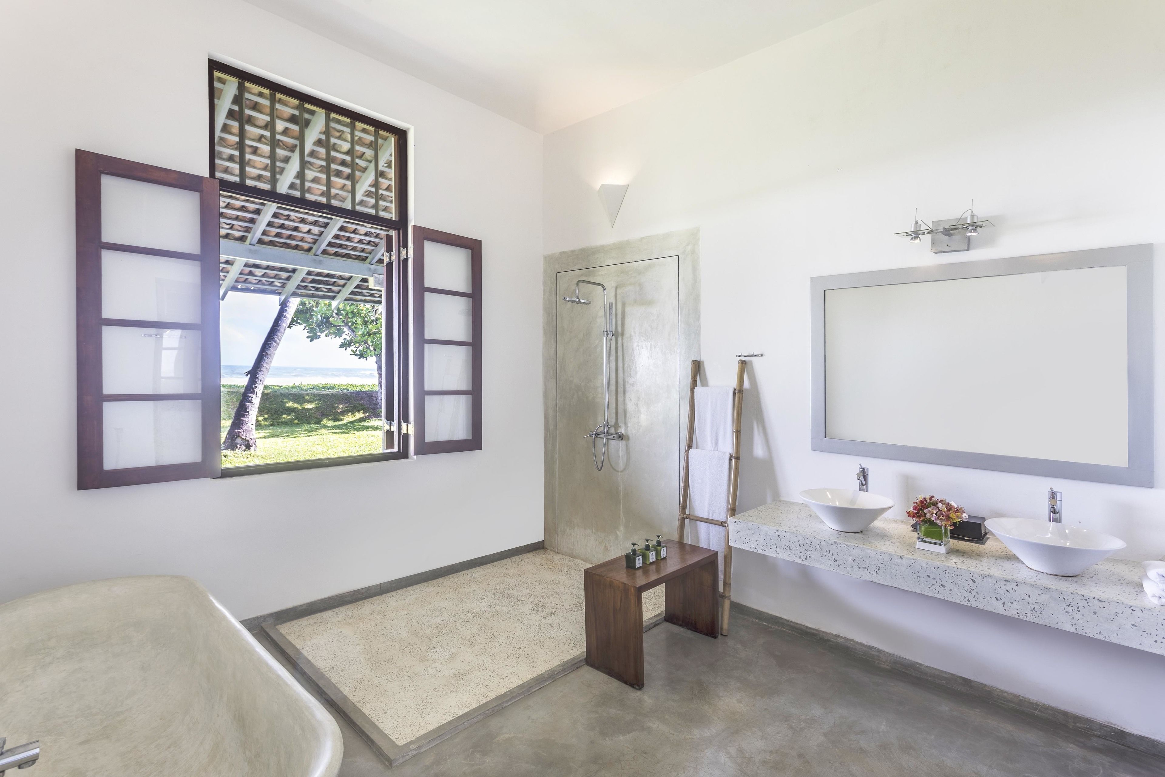 A bathroom with a bathtub, a shower, a vanity with two sinks, and a large mirror.