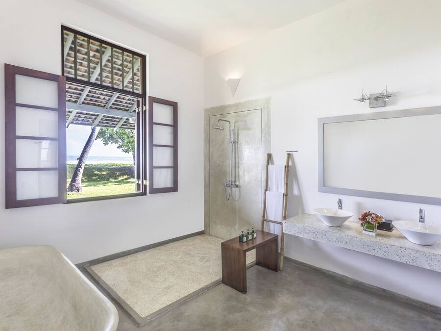 A bathroom with a bathtub, a shower, a vanity with two sinks, and a large mirror.