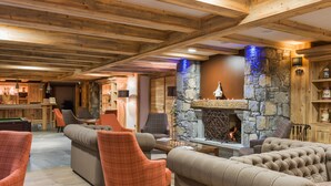 A cozy lounge area with sofas, chairs, a fireplace, and a pool table. -  CGH Résidence Boutique les Chalets de Laÿssia (Samoëns)