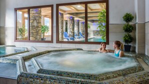 A hot tub area with mosaic tiles, stone pillars, and potted plants. -  CGH Résidence Boutique les Chalets de Laÿssia (Samoëns)