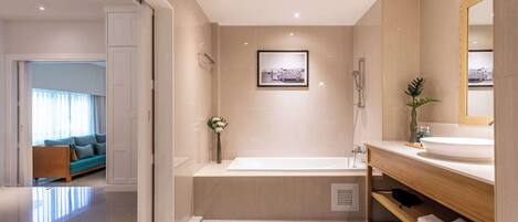 A modern bathroom with a bathtub, a large mirror, and a sink.