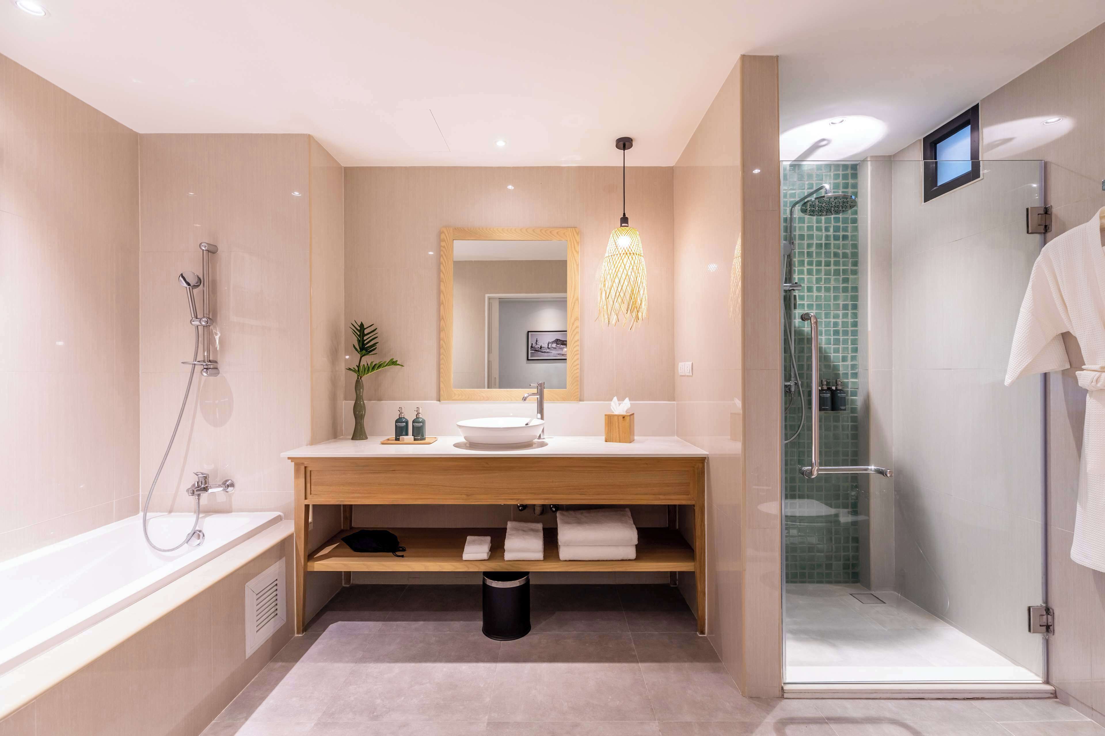 Un bagno moderno con una vasca, un lavabo con specchio, una zona doccia e un box doccia in vetro.