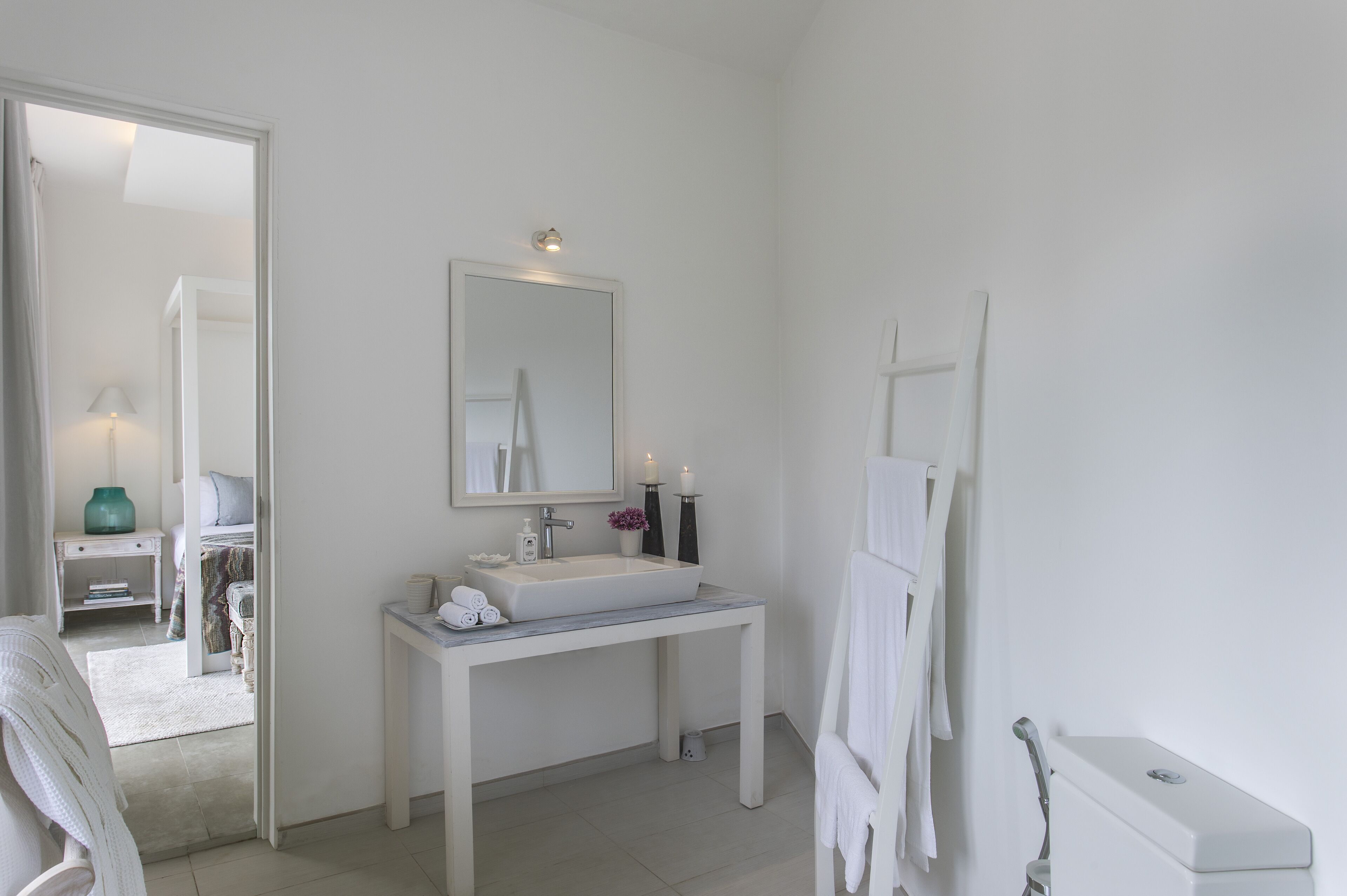 Un baño moderno con un tocador blanco, un espejo grande y una zona de ducha.