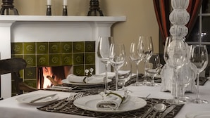 A dining table set for a meal with a fireplace in the background. - Hill Rise Luxury Villa & Stables by Edwards Collection (Nuwara Eliya)