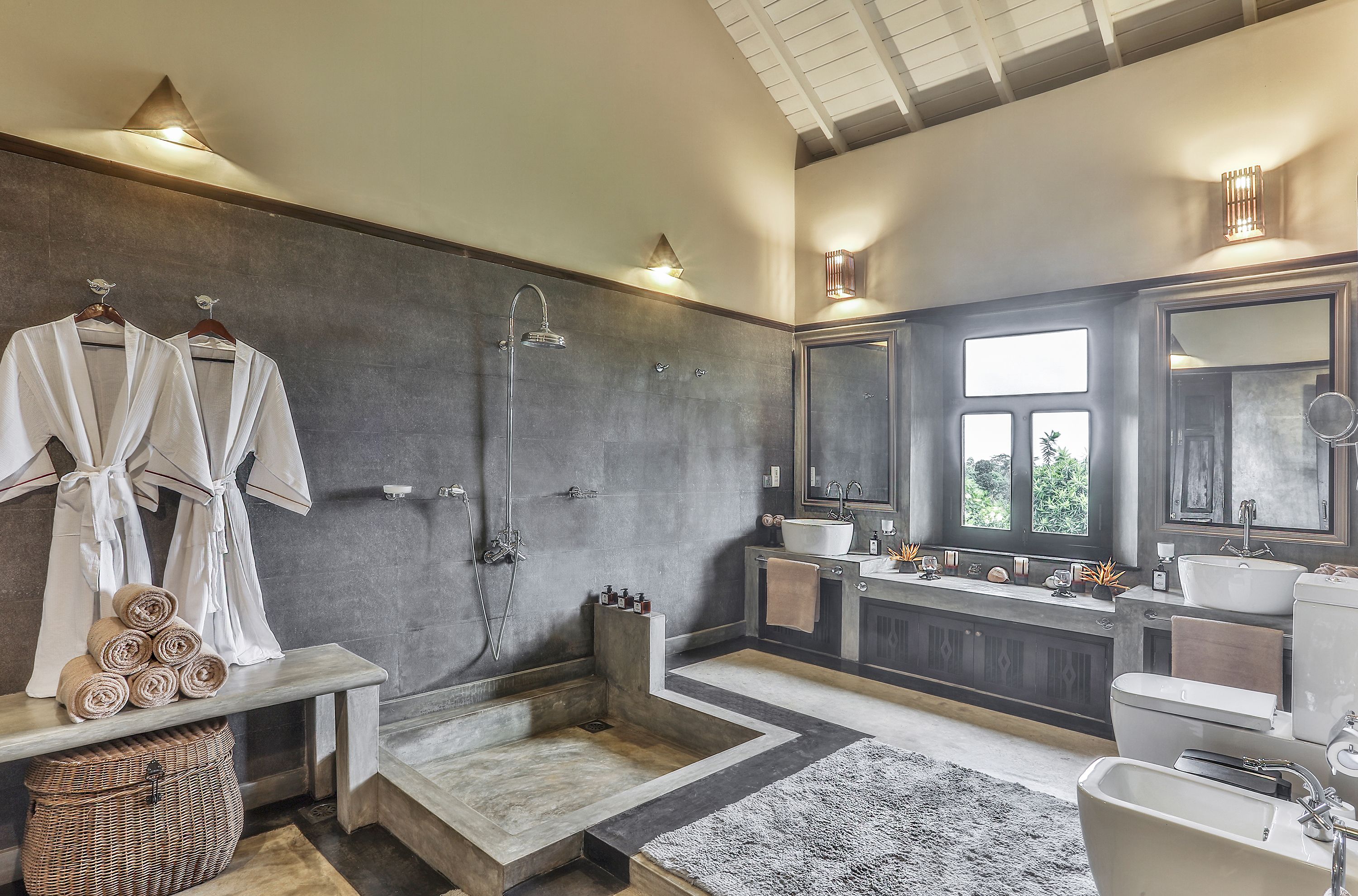 Un baño moderno con cabina de ducha, un espejo grande y un tocador con dos lavamanos.