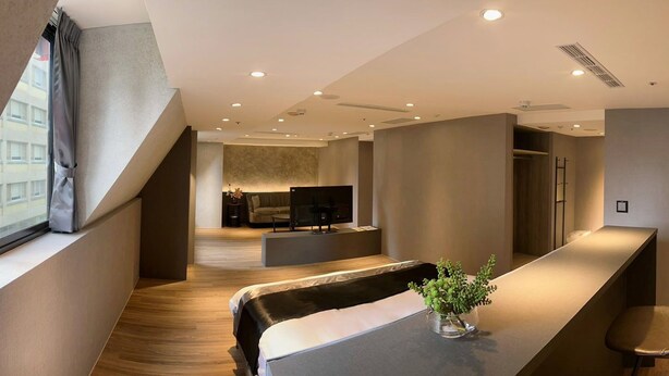 Une chambre d’hôtel moderne dotée d’un grand lit, d’un coin repas et d’une kitchenette.