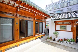 Un bâtiment japonais traditionnel, caractérisé par ses poutres en bois, ses grandes portes coulissantes et son toit recouvert de tuiles.