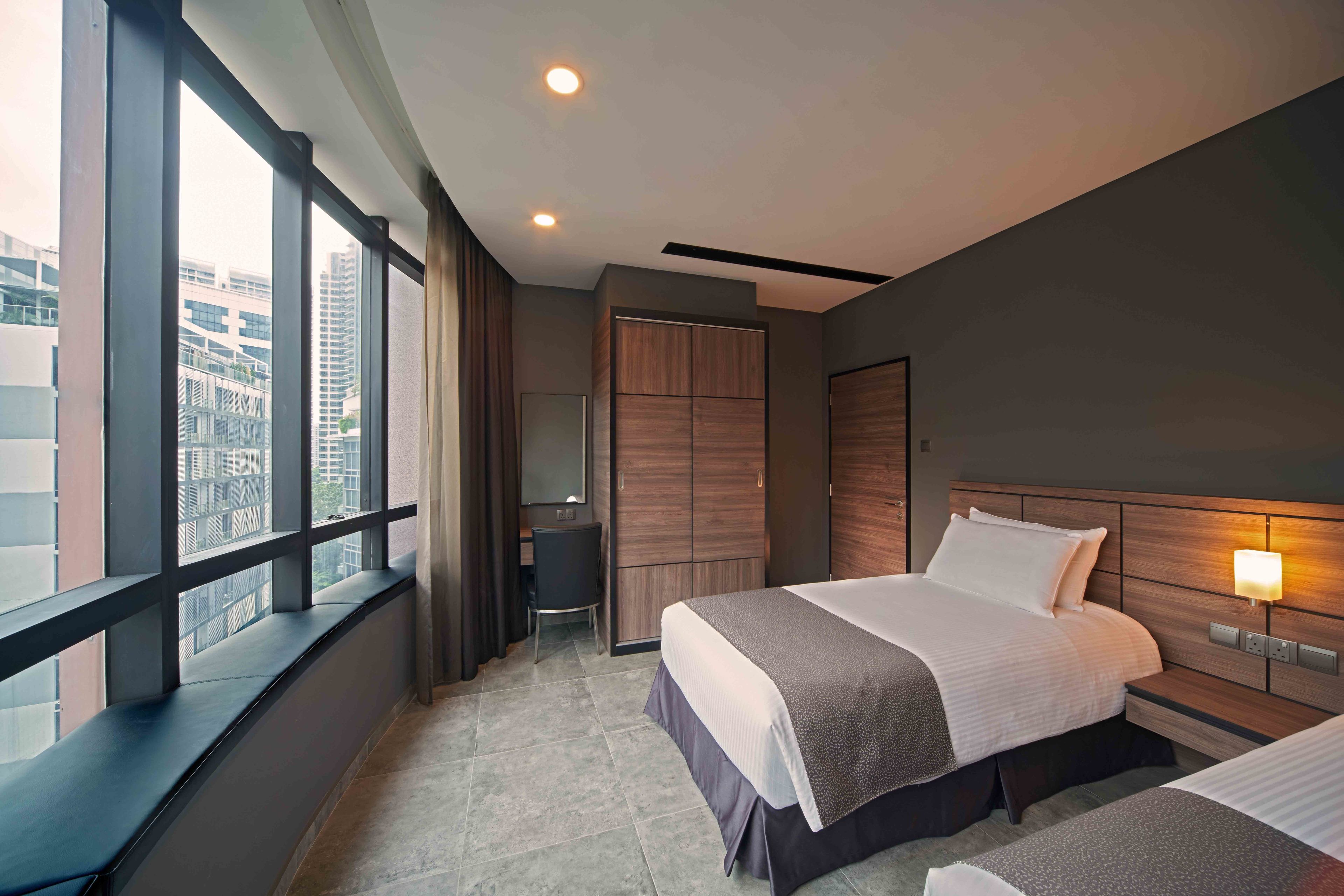 A modern hotel room with a large window, a bed, a desk, and a wardrobe. - Orchard Grand Court (Singapore)