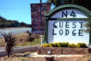 A sign for 'N4 Guest Lodge' with a clear view of the entrance and surrounding landscaping. - N4 Guest Lodge (Kgetlengrivier)