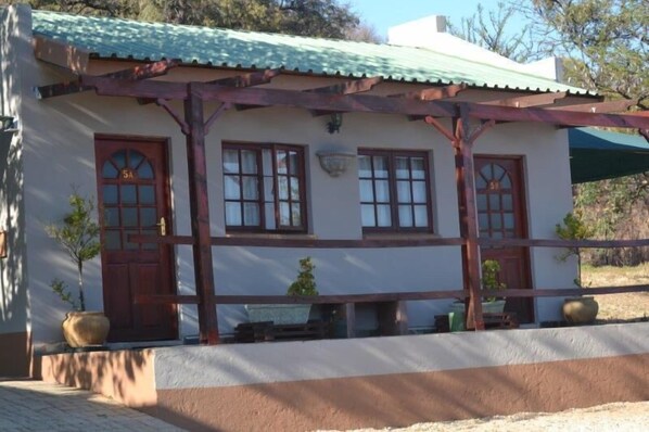 A two-story building with a green roof, wooden beams, and a white facade. - N4 Guest Lodge (Kgetlengrivier)