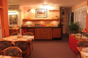 Comedor con isla central, sillas de madera y mantel rojo.