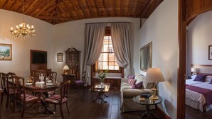 A cozy room with a dining area, a sofa, and a bed.