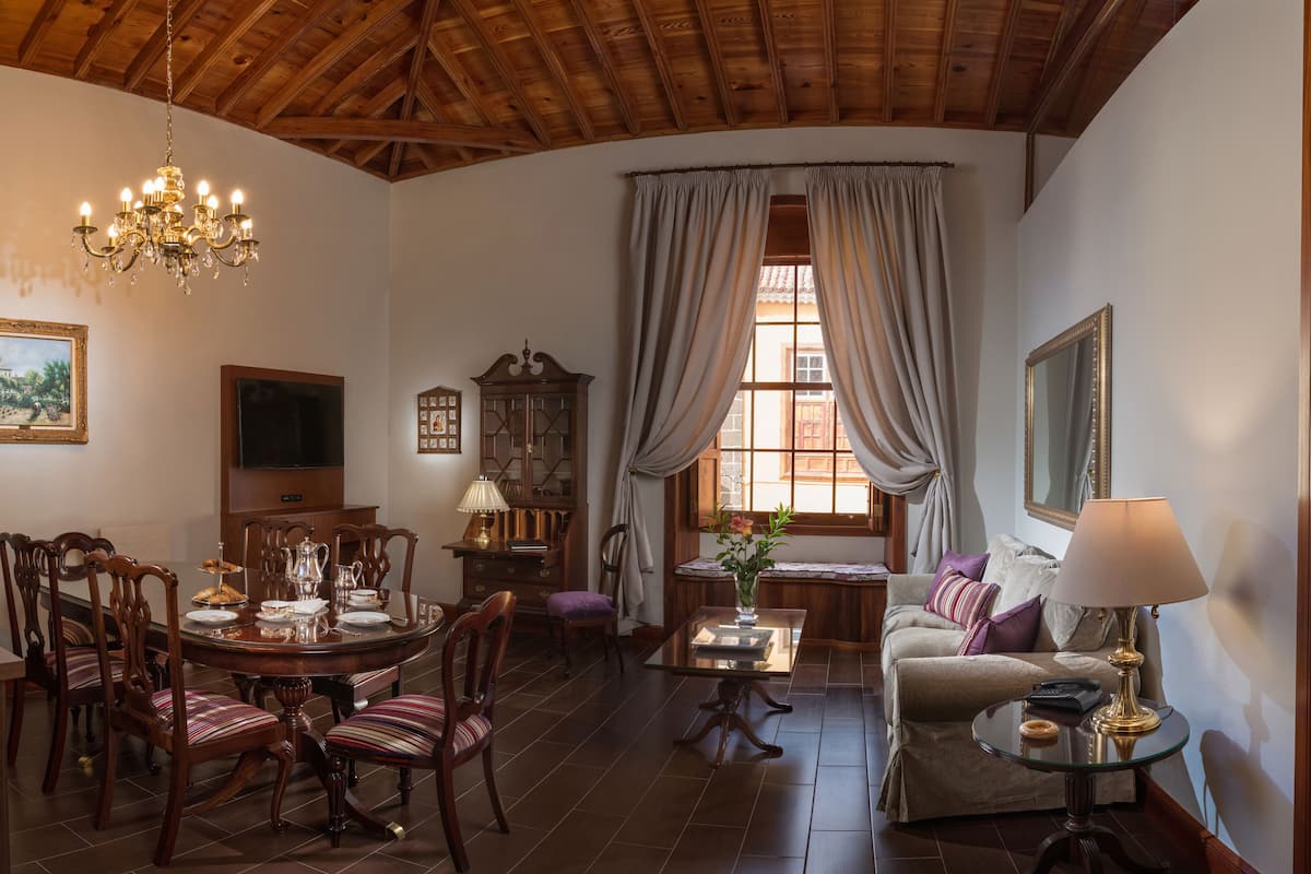 Um quarto aconchegante com área de jantar, sofá e cama.