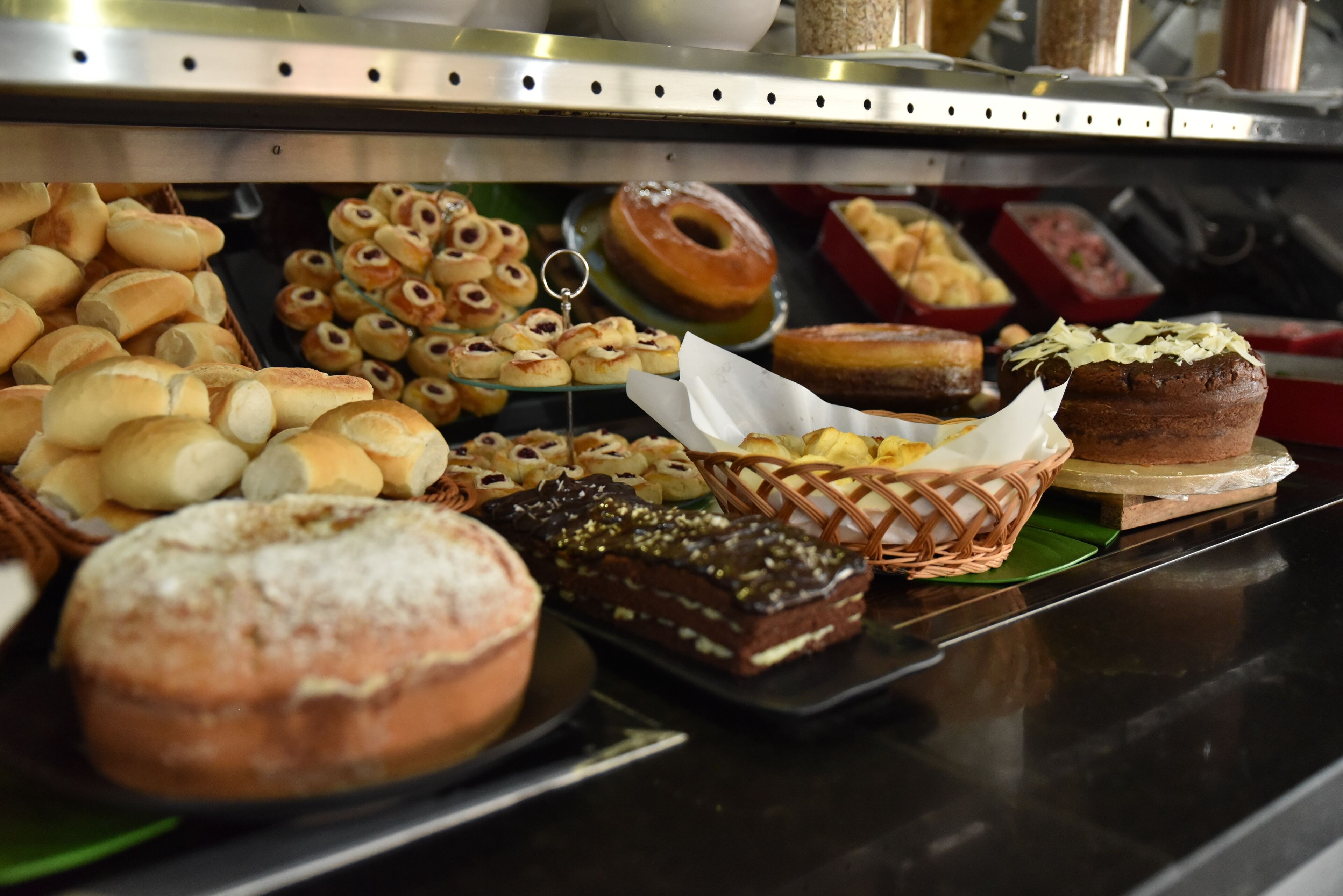 Une variété de produits de boulangerie et de pâtisserie est exposée, notamment des viennoiseries, des beignets et du pain.