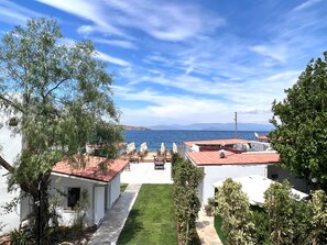 A coastal property with a view of the sea, white buildings, and a well-maintained lawn. - Lavinya Otel (Bodrum)